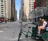 A joyful group of people are taking pedicab rides in what appears to be a city park setting smiling and posing for a group selfie