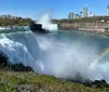 This is an image showing the majestic Niagara Falls with a vibrant rainbow arching over the mist and a city skyline in the background