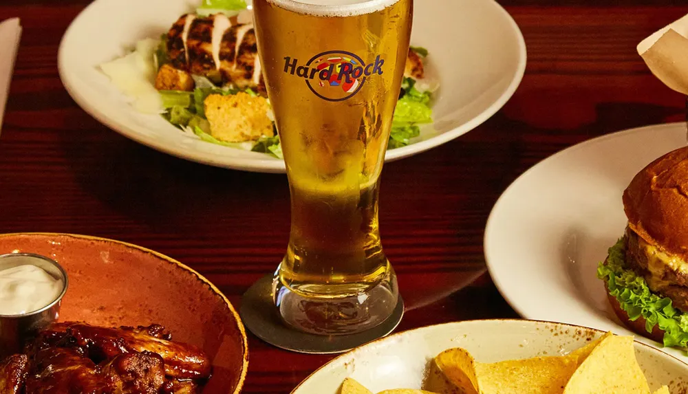 The image features a variety of pub-style food including a salad a glass of beer barbecued wings and a burger suggesting a casual dining experience