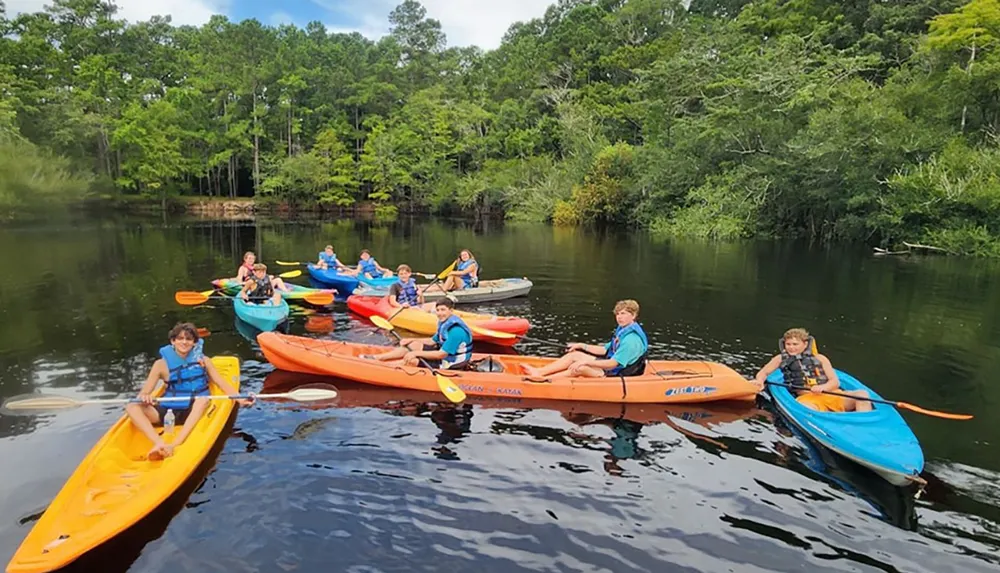 A group of people are enjoying a kayaking excursion on a calm river surrounded by lush greenery