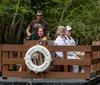 A group of people is enjoying a scenic boat tour on a calm river amidst a forested area