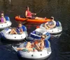 A group of people are enjoying a sunny day on the water floating in individual inflatable rafts tied together