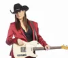 A person in a red suit and black cowboy hat is holding a cream-colored electric guitar