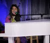 The image features a woman lying on a piano in a colorful outfit and boots with the text Tapestry the Carole King Songbook