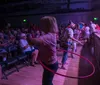 A saxophonist in a tropical shirt plays energetically among an audience at a lively indoor concert