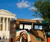 A hop-on hop-off tour trolley passes in front of the US Capitol building on a sunny day