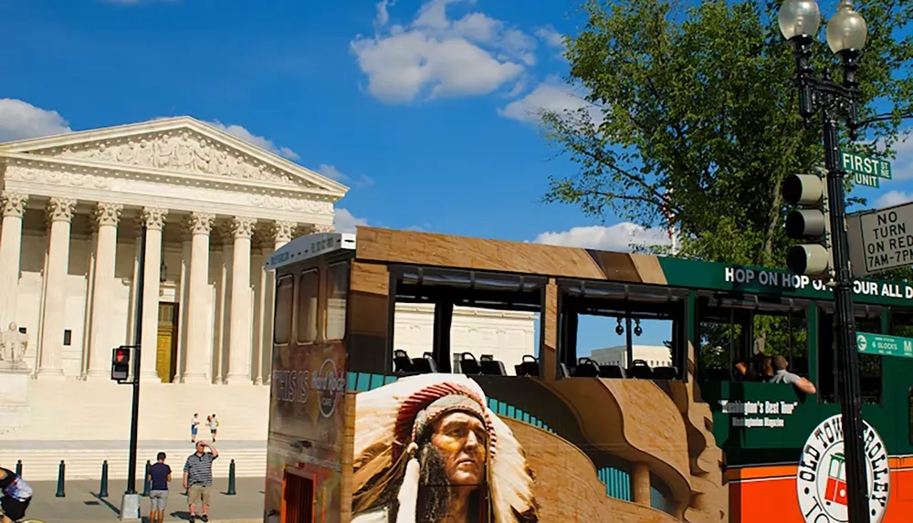 An open-top sightseeing trolley bus passes by the United States Supreme Court building on a sunny day