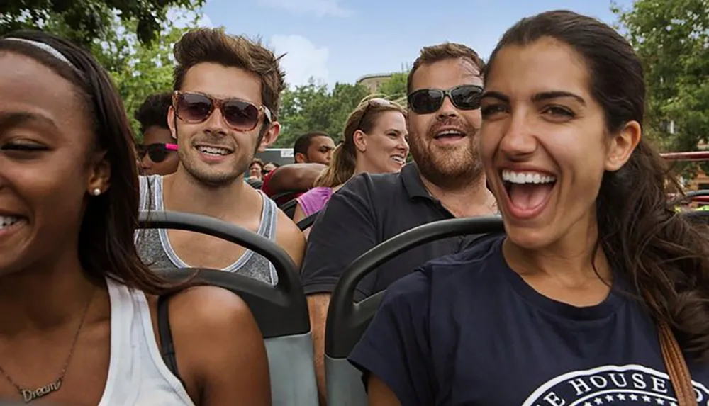 A group of people smiling and enjoying a ride on a sunny day