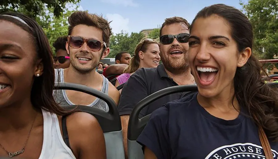 A group of people smiling and enjoying a ride on a sunny day.