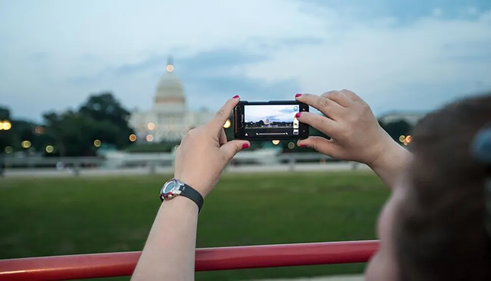 A person is taking a photo of a building with a smartphone