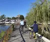 A group of people wearing bright green helmets are cycling along a tree-lined path