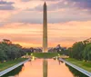 The image shows the Washington Monument reflected in the Lincoln Memorial Reflecting Pool at sunset framed by trees