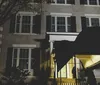 The image shows the White House at night illuminated with dim lights against a dark sky