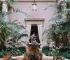 The image depicts a bronze statue of Mercury atop a pedestal within an interior space with tall columns and a skylight