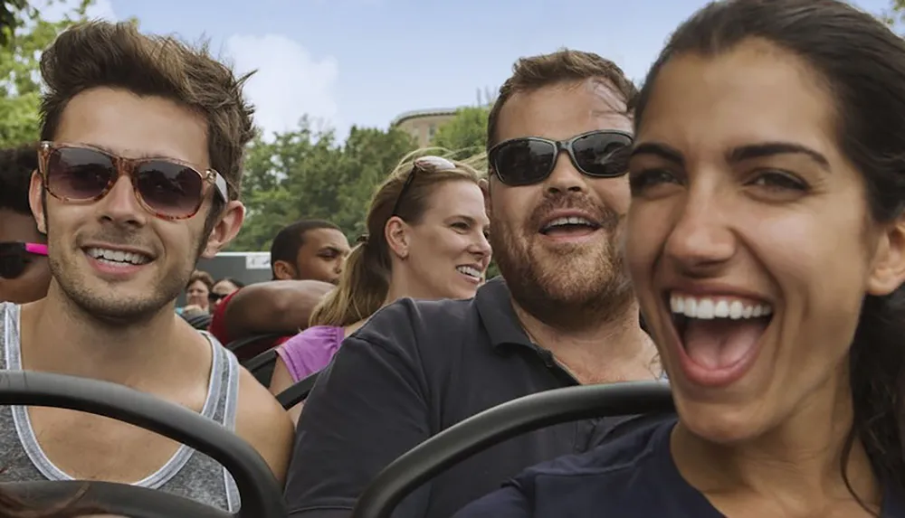 A group of people are delightedly enjoying a roller coaster ride outdoors