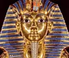 The image shows the famous golden mask of Tutankhamun adorned with blue stripes a symbol of ancient Egyptian royalty