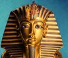 The image shows the famous golden mask of Tutankhamun adorned with blue stripes a symbol of ancient Egyptian royalty