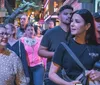 A group of people are joyfully clinking glasses in a bar setting